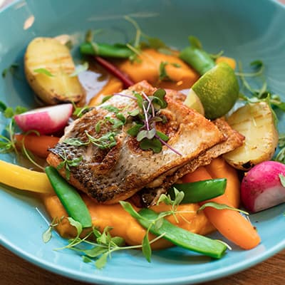 Proteína en la perimenopausia: cuánto necesitas y cómo repartirla durante el día Plato con pescado y verduras, fuente de proteína para una alimentación equilibrada